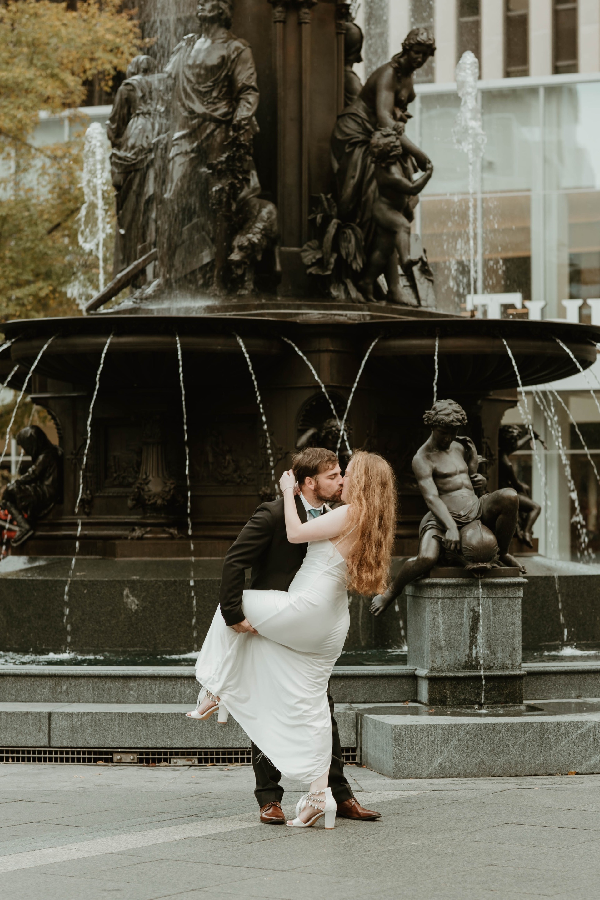Couple kissing in front of the Tyler Davidson Fountain at golden hour